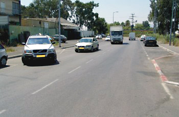 איור לשאלה: בתמונה שלפניך, תגובת הנוהגים בדרך לרכב היוצא מהחנייה אינה ברורה. כיצד צריך להגיב נהג המשאית במצב זה?