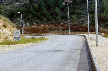 איור לשאלה: בתמונה שלפניך יש כמה גורמי דרך. מה צריכה להיות תגובת הנהג בהתקרבו למקום?
