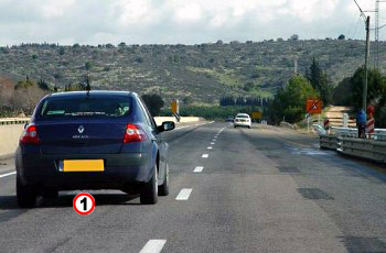 איור לשאלה: מה אינו נכון בהתנהגותו של נהג הרכב הכחול (1)?