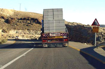 איור לשאלה: נסיעה בעקבות הרכב הכבד ובתנאי הדרך הנתונים מחייבת את הנוהג ברכב: