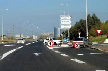 איור לשאלה: הרכב הלבן (1) שבצומת והרכב הכסוף (2) מתכוונים להיכנס לאותה דרך. מי מהם חייב לתת זכות קדימה?